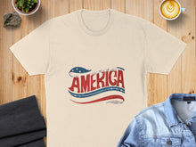 Load image into Gallery viewer, Cream t-shirt with "AMERICA" in red, white, and blue stars and stripes design.
