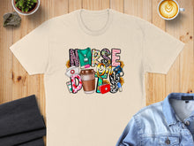 Load image into Gallery viewer, Cream t-shirt with "Nurse Life" text and medical icons.
