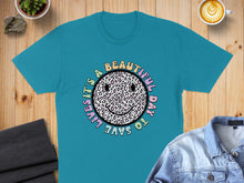 Load image into Gallery viewer, Teal t-shirt with a leopard print smiley face and text "It's a beautiful day to save lives".
