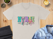 Load image into Gallery viewer, "Nurse Life" text with stethoscope and syringes on a tan t-shirt.
