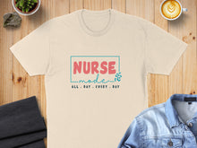 Load image into Gallery viewer, Cream t-shirt with "Nurse Mode" text and coffee cup, denim jacket, and folded fabric.

