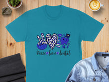 Load image into Gallery viewer, Teal t-shirt with blue leopard print peace sign and dental graphics.
