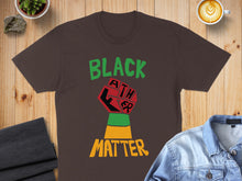 Load image into Gallery viewer, Brown t-shirt with "Black Lives Matter" fist graphic and green and yellow stripes.
