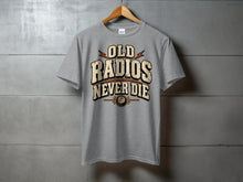 Load image into Gallery viewer, Grey t-shirt with "Old Radios Never Die" graphic and radio dial icon.
