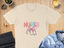 Load image into Gallery viewer, Cream t-shirt with "Nurse" text, stethoscope, and floral accents.
