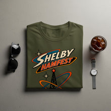 Load image into Gallery viewer, Olive green t-shirt with "SHELBY HAMFEST" logo and a radio tower graphic.
