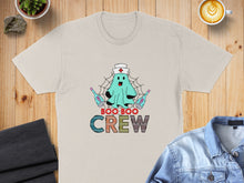 Load image into Gallery viewer, Cream t-shirt with a cartoon ghost nurse and "Boo Boo Crew" text.
