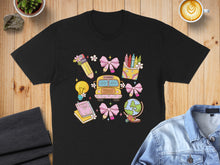 Load image into Gallery viewer, Black t-shirt featuring cartoon school supplies, bus, and globe in bright colors.
