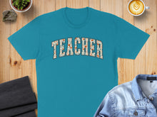 Load image into Gallery viewer, Teal t-shirt with "TEACHER" in floral block letters.
