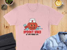 Load image into Gallery viewer, Pink t-shirt with "Spooky Vibes &amp; That Nurse Life" text and a pumpkin nurse graphic.
