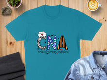 Load image into Gallery viewer, Turquoise t-shirt with "CNA certified nursing assistant" text and Halloween-themed graphics.
