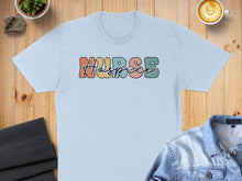 Load image into Gallery viewer, Light blue t-shirt with "NURSE" in colorful retro lettering.
