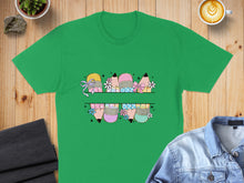 Load image into Gallery viewer, Green t-shirt featuring colorful pencils with bows and flowers design.
