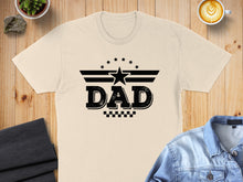 Load image into Gallery viewer, Black "DAD" text with stars and checkered pattern on a beige t-shirt.

