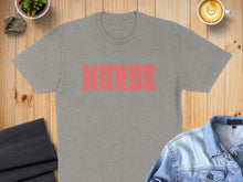 Load image into Gallery viewer, Gray t-shirt with distressed red "NURSE" text, laid flat on wood.
