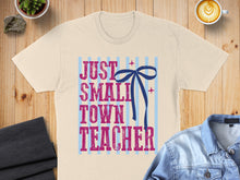 Load image into Gallery viewer, T-shirt with text "JUST SMALL TOWN TEACHER" and a blue bow.
