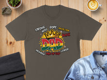 Load image into Gallery viewer, Dark t-shirt with "DAD" graphic featuring crown and words Strong Hero Protector Leader.
