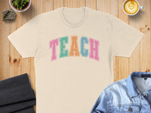 Load image into Gallery viewer, Cream t-shirt with "TEACH" in colorful letters.
