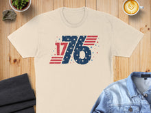 Load image into Gallery viewer, Beige t-shirt with distressed "1776" American flag graphic.
