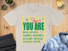 Load image into Gallery viewer, T-shirt with "YOU ARE kind, smart, helpful, grateful, enough, strong, unique, loved" text and a pink bow.

