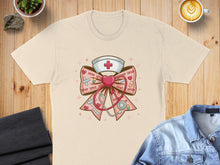 Load image into Gallery viewer, T-shirt featuring a nurse's hat, stethoscope, and "XOXO" pattern on a bow.
