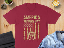 Load image into Gallery viewer, Maroon t-shirt with "America Victory Day May 08" text and distressed flag design.
