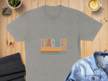 Load image into Gallery viewer, Grey t-shirt with "TEACHER" and inspiring words in colorful stripes.
