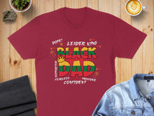 Load image into Gallery viewer, Maroon t-shirt with "Black Dad Leader King Supportive Fearless Confident" text and flag colors.
