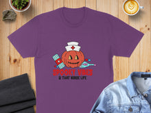 Load image into Gallery viewer, Purple t-shirt with a Halloween pumpkin nurse graphic and text.
