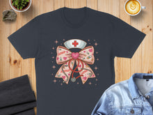 Load image into Gallery viewer, Dark t-shirt featuring a pink bow with stethoscope, hearts, and "XOXO" text.
