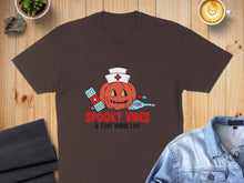 Load image into Gallery viewer, Brown t-shirt with "Spooky Vibes &amp; That Nurse Life" text and Halloween nurse graphic.

