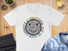 Load image into Gallery viewer, White t-shirt with colorful leopard print smiley face and text.
