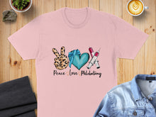 Load image into Gallery viewer, Pink t-shirt with "Peace Love Phlebotomy" text, heart, and syringes.
