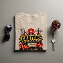 Load image into Gallery viewer, Cream t-shirt with "CAUTION:" text, warning light, and meter graphic.
