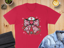 Load image into Gallery viewer, Red t-shirt with a pink bow featuring a stethoscope and heart.

