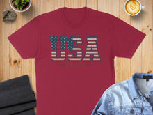 Load image into Gallery viewer, Crimson t-shirt with "USA" text and stars, laid flat with denim jacket.
