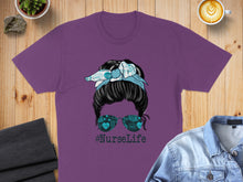 Load image into Gallery viewer, Purple t-shirt with messy bun, bandana, and "#NurseLife" text.
