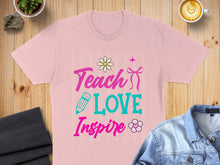 Load image into Gallery viewer, Pink t-shirt with "Teach Love Inspire" text and floral graphics.
