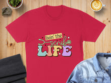 Load image into Gallery viewer, Red t-shirt with "Livin' the Scrub Life" graphic in colorful lettering.
