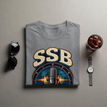 Load image into Gallery viewer, Grey t-shirt with SSB logo featuring microphone, globe, and frequency bands.
