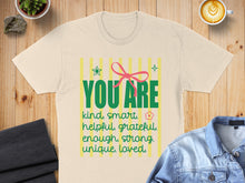 Load image into Gallery viewer, Cream t-shirt with "YOU ARE kind. smart. &amp; helpful. grateful. enough, strong. unique, loved." design.
