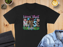 Load image into Gallery viewer, Black t-shirt with "Livin' that Nurse Life" text and medical icons.
