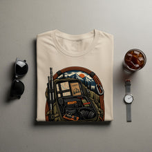 Load image into Gallery viewer, Cream t-shirt with backpack graphic featuring radio, headphones, and mountain sunset.
