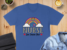 Load image into Gallery viewer, Blue t-shirt with "Nurse Love Inspire Heal" text and rainbow stethoscope.
