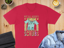 Load image into Gallery viewer, Red t-shirt with text "Not all heroes wear capes, some wear scrubs" and rainbow stethoscope.
