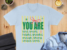 Load image into Gallery viewer, Light blue t-shirt with "YOU ARE kind, smart, helpful, grateful, enough, strong, unique, loved."
