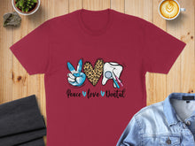 Load image into Gallery viewer, Burgundy t-shirt with "Peace Love Dental" text and dental graphics.
