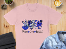 Load image into Gallery viewer, Pink t-shirt with "Peace Love Dental" text and dental graphics.

