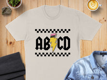 Load image into Gallery viewer, Cream t-shirt with "ABCD" and a lightning bolt graphic.
