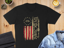 Load image into Gallery viewer, Black t-shirt with distressed American flag and "We The People" text.

